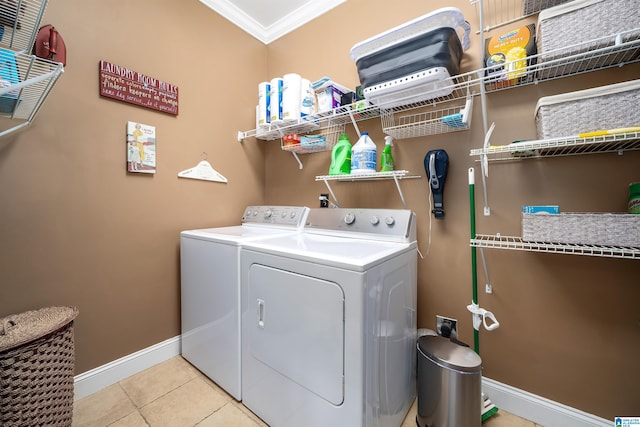 clothes washing area featuring light tile patterned floors, crown molding, and independent washer and dryer