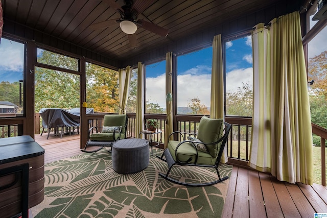 sunroom with a healthy amount of sunlight, ceiling fan, and wooden ceiling