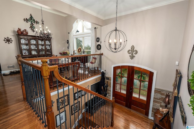 stairway featuring ornamental molding, french doors, hardwood / wood-style floors, and a chandelier