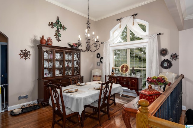 dining space with dark wood-type flooring, a chandelier, and crown molding