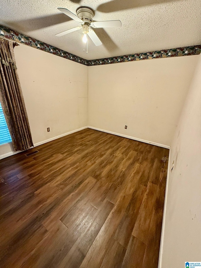 spare room featuring a textured ceiling, dark hardwood / wood-style floors, and ceiling fan