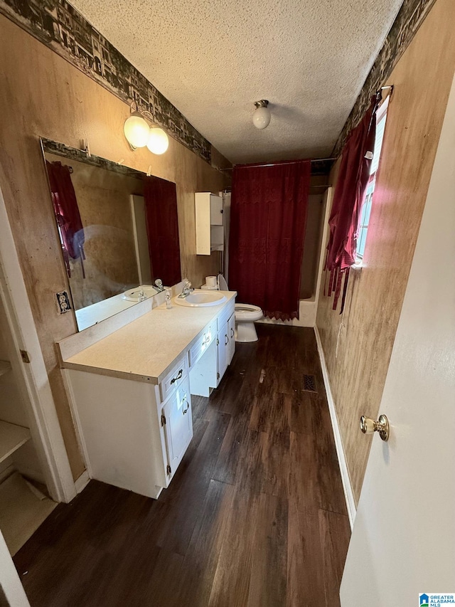 bathroom with hardwood / wood-style floors, vanity, a textured ceiling, and toilet