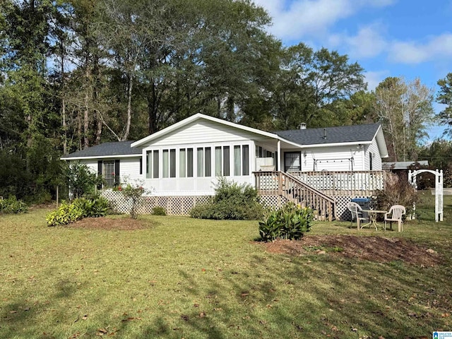 back of house with a sunroom and a yard