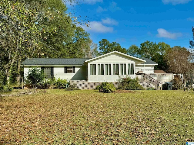 back of house with a sunroom and a lawn