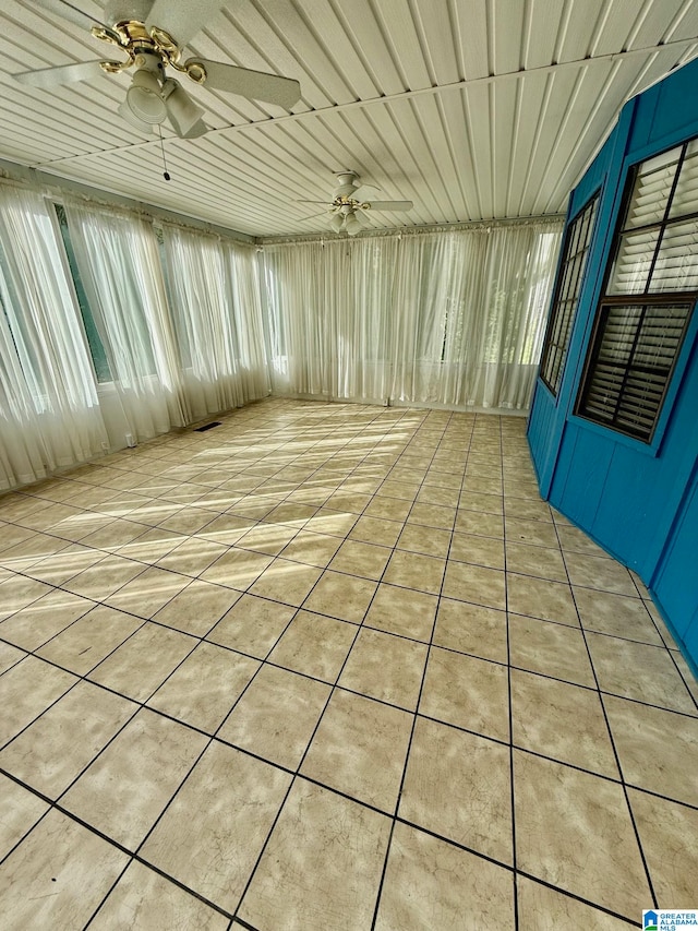 unfurnished sunroom featuring ceiling fan