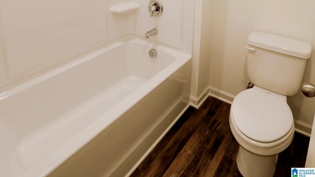 bathroom with toilet, a washtub, and hardwood / wood-style flooring