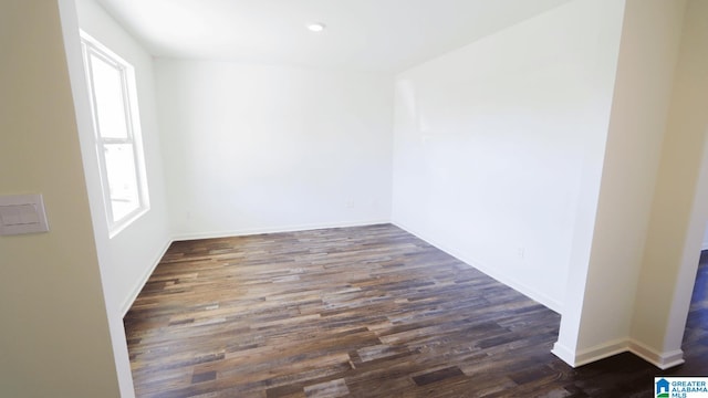 empty room featuring a wealth of natural light and dark hardwood / wood-style flooring