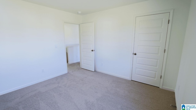 unfurnished room featuring light colored carpet