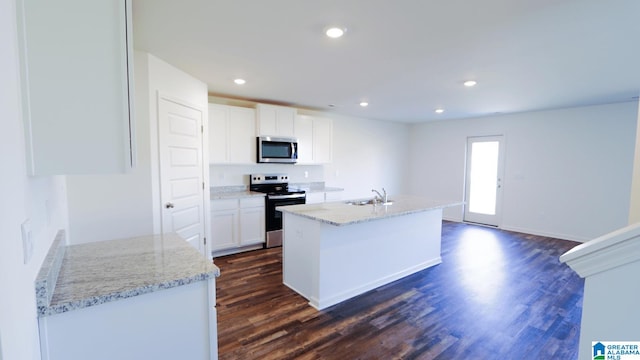 kitchen featuring stainless steel appliances, light stone countertops, white cabinets, and dark hardwood / wood-style flooring