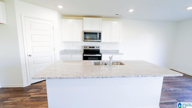 kitchen with stainless steel appliances, white cabinetry, an island with sink, and sink