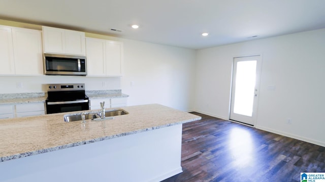 kitchen with dark hardwood / wood-style flooring, light stone counters, white cabinets, sink, and appliances with stainless steel finishes