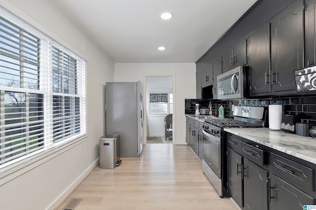 kitchen featuring a wealth of natural light, stainless steel appliances, and backsplash