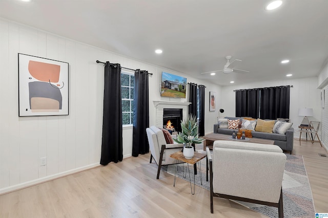 living room with light hardwood / wood-style floors and ceiling fan