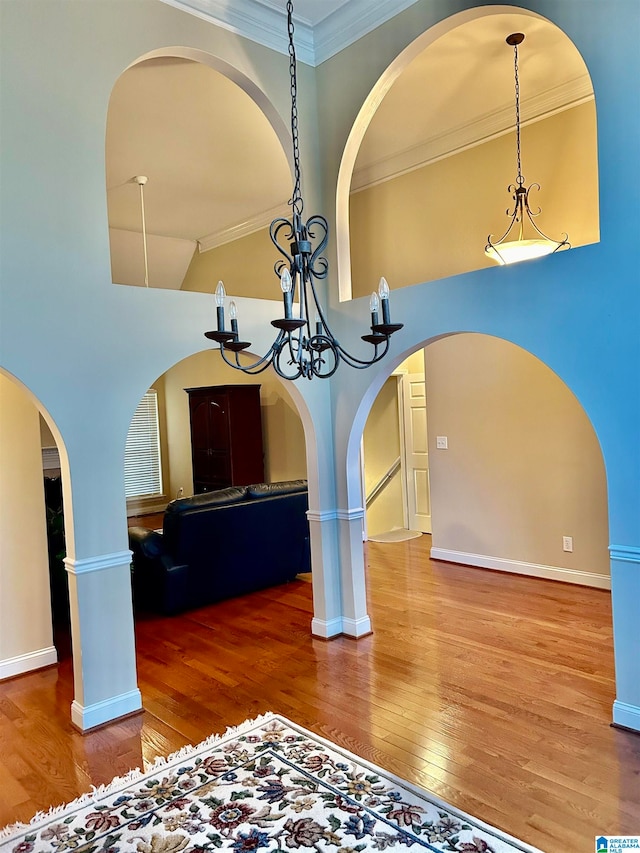 room details with an inviting chandelier, wood-type flooring, and ornamental molding