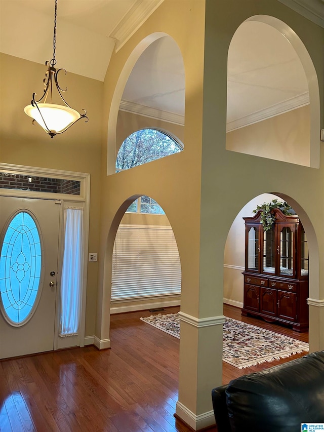 entrance foyer featuring hardwood / wood-style floors, a high ceiling, and ornamental molding