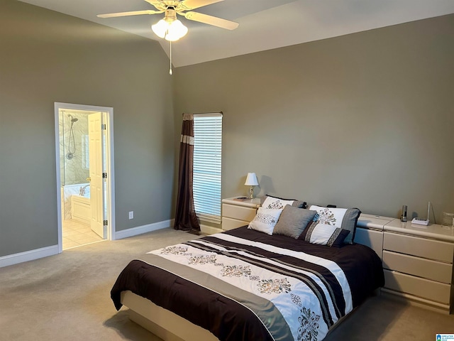 bedroom featuring connected bathroom, vaulted ceiling, light carpet, and ceiling fan