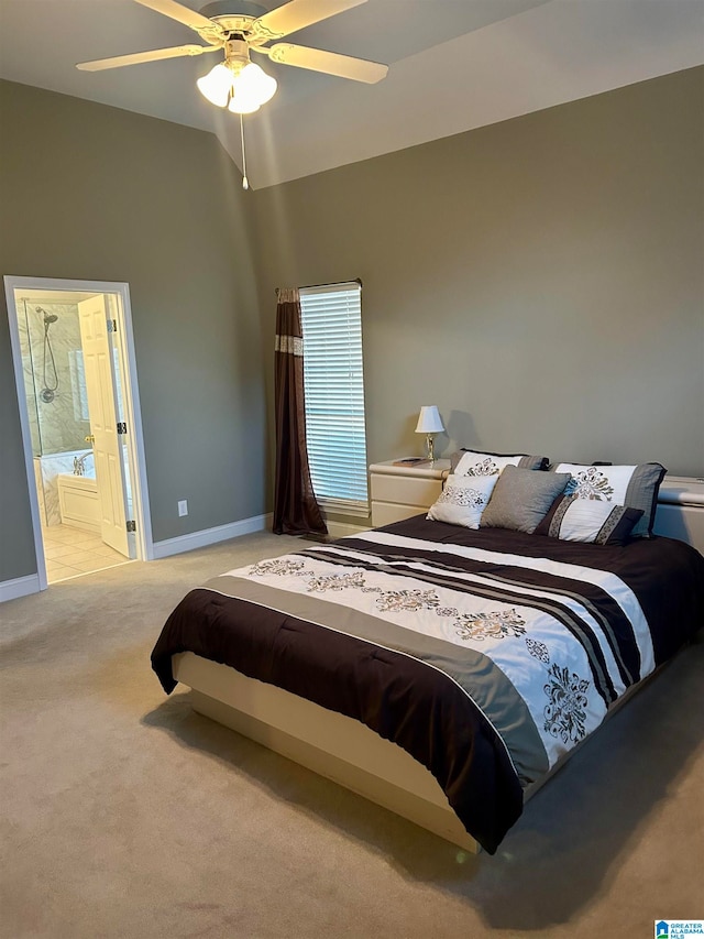 bedroom featuring ensuite bath, light carpet, and ceiling fan