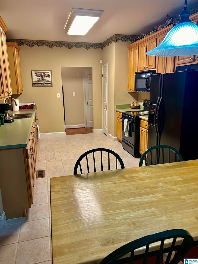 kitchen featuring black appliances, sink, and light tile patterned floors