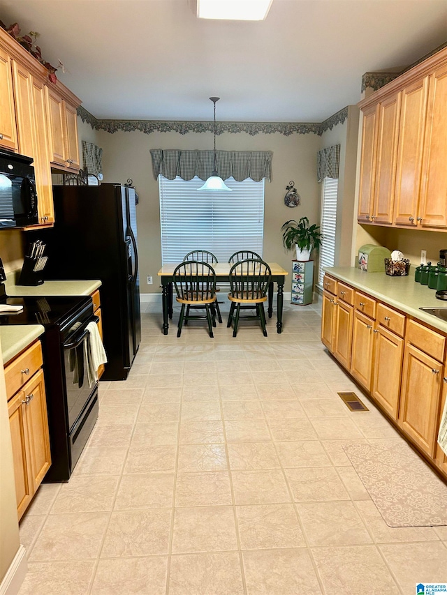 kitchen with pendant lighting, light tile patterned flooring, and black appliances