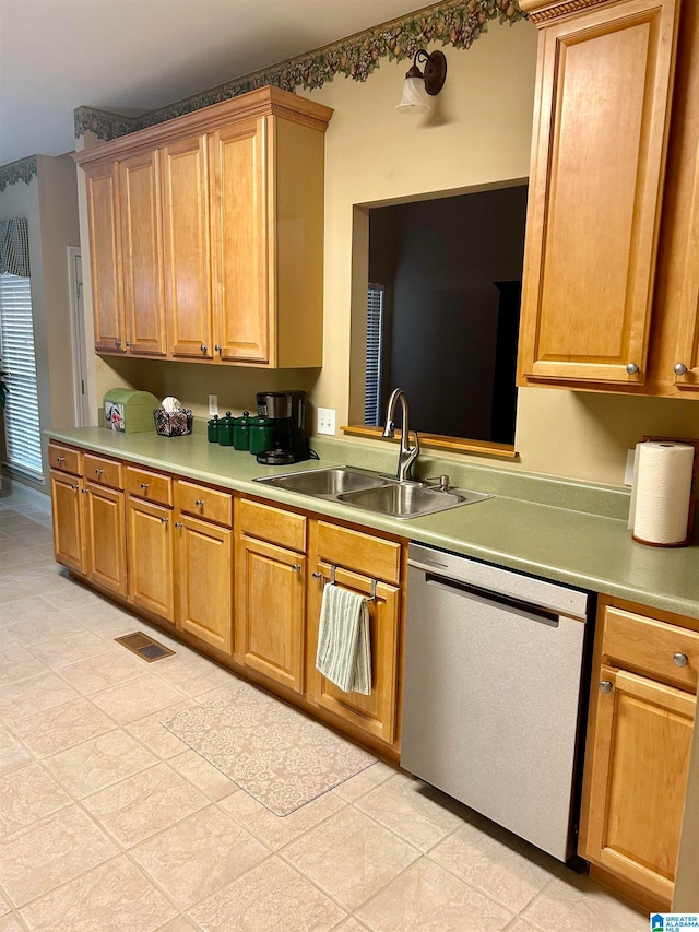 kitchen featuring dishwasher, sink, and light tile patterned flooring