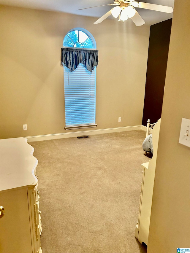 carpeted empty room featuring ceiling fan