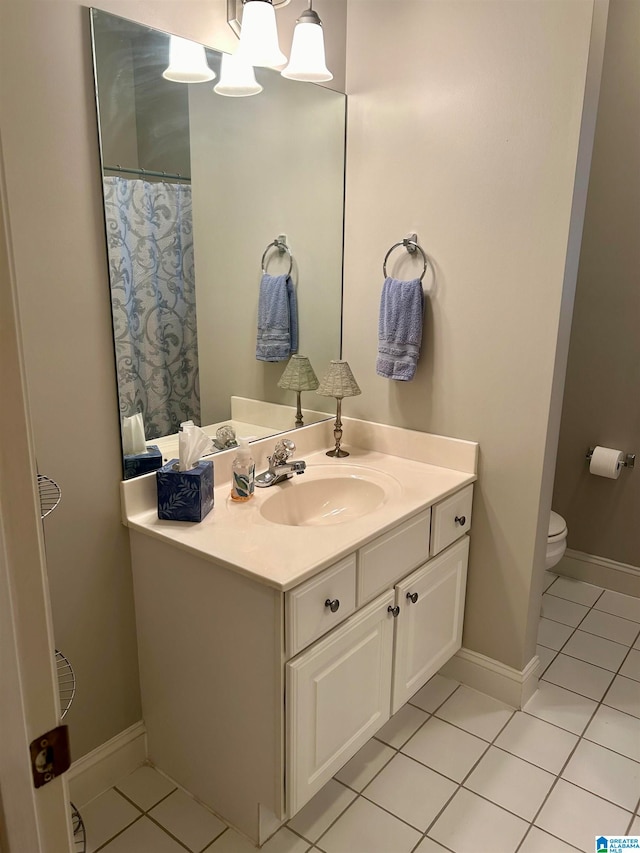 bathroom featuring vanity, tile patterned flooring, and toilet