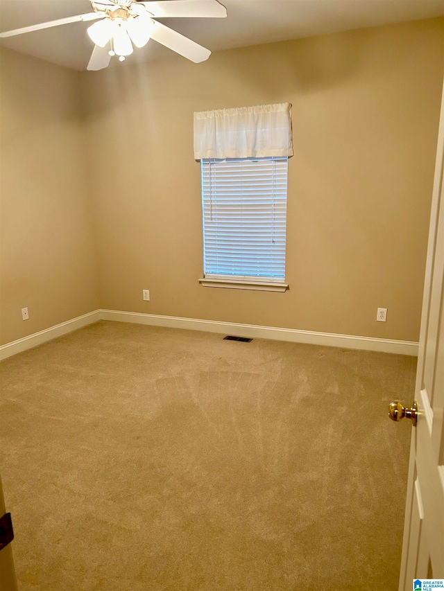 carpeted spare room featuring ceiling fan