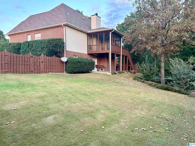 back of property featuring a sunroom and a yard