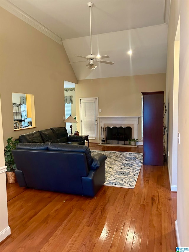 living room featuring ornamental molding, ceiling fan, high vaulted ceiling, and light hardwood / wood-style floors