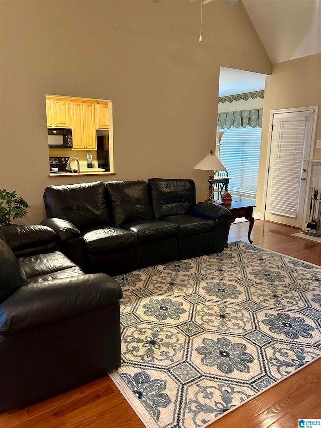 living room featuring dark wood-type flooring and high vaulted ceiling