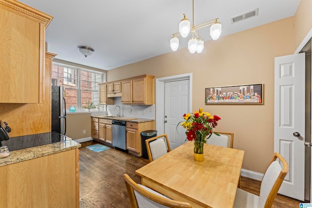 kitchen featuring appliances with stainless steel finishes, dark wood-type flooring, hanging light fixtures, and light brown cabinetry