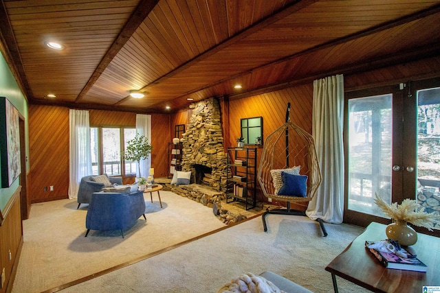 carpeted living room with a fireplace, beamed ceiling, wooden ceiling, and wood walls