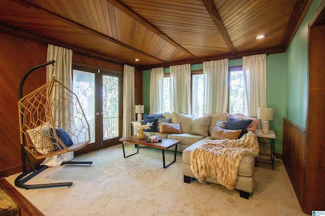 interior space with plenty of natural light, wood ceiling, light carpet, and wooden walls