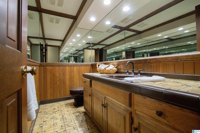 bathroom featuring wood walls, vanity, and toilet