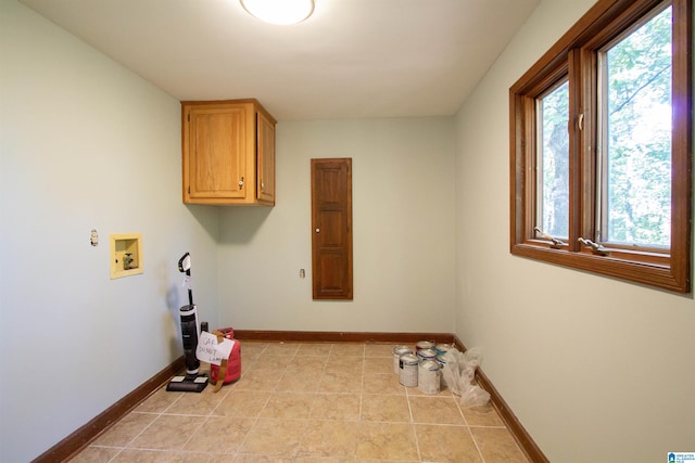 clothes washing area featuring cabinets, hookup for a washing machine, and light tile patterned floors