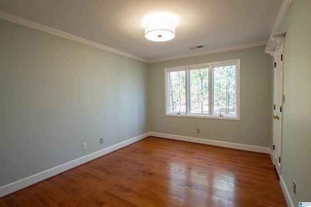 spare room featuring hardwood / wood-style flooring and crown molding