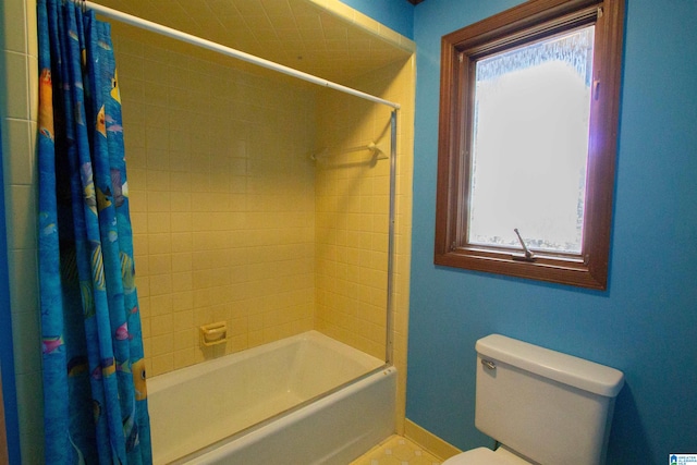 bathroom with a wealth of natural light, shower / tub combo with curtain, and toilet