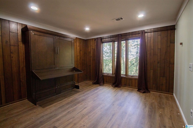 mudroom featuring wood-type flooring and wooden walls