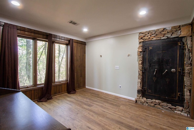 entrance foyer with a stone fireplace and wood-type flooring