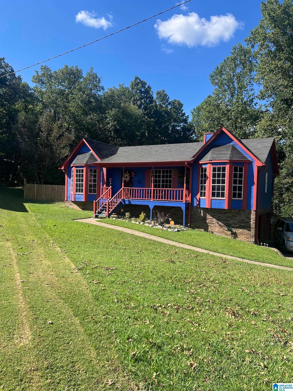 single story home featuring covered porch and a front lawn