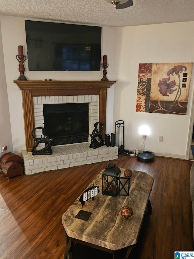 living room with hardwood / wood-style flooring, a fireplace, and a textured ceiling