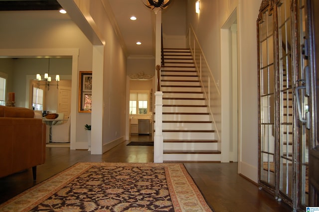 foyer featuring a high ceiling, a notable chandelier, and ornamental molding