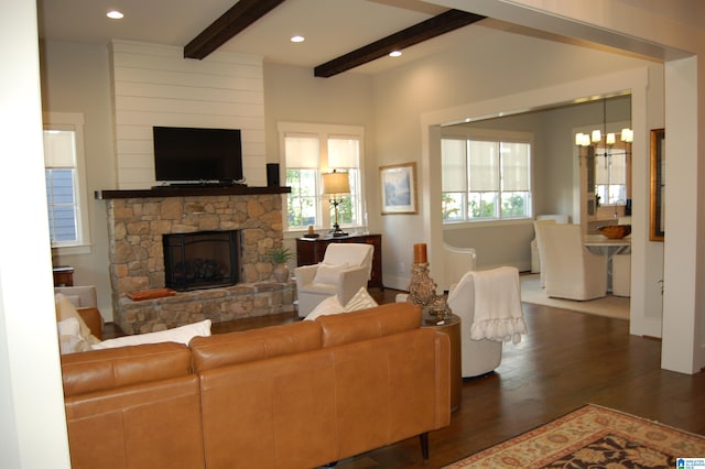 living room with a stone fireplace, beam ceiling, dark hardwood / wood-style floors, and plenty of natural light