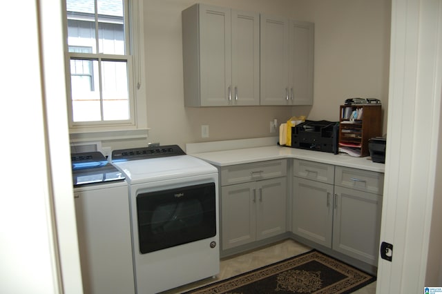 clothes washing area with cabinets and independent washer and dryer