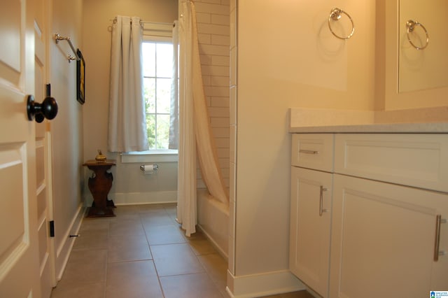 bathroom with shower / bath combo with shower curtain and tile patterned flooring