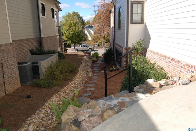 view of side of property featuring central air condition unit and a patio area