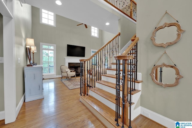 staircase with hardwood / wood-style flooring and a high ceiling