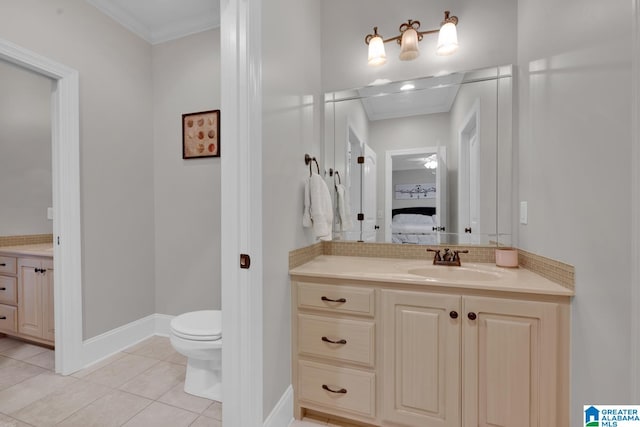 bathroom featuring toilet, vanity, tile patterned flooring, and ornamental molding