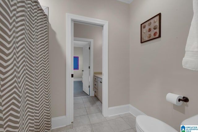 bathroom with toilet, vanity, and tile patterned floors