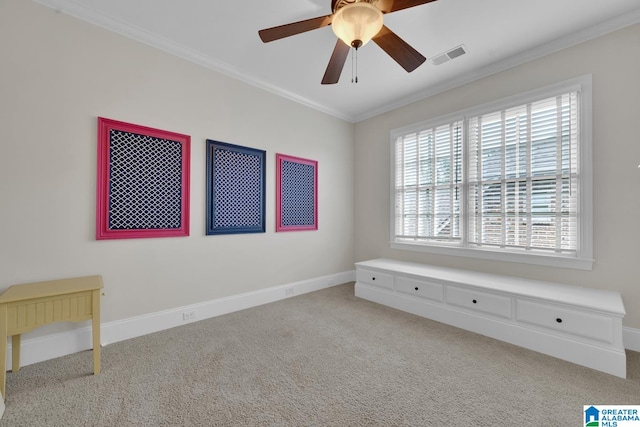 empty room featuring ornamental molding, light colored carpet, and ceiling fan